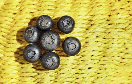  Fresh blueberries on yellow background, ripe and tasty fruit