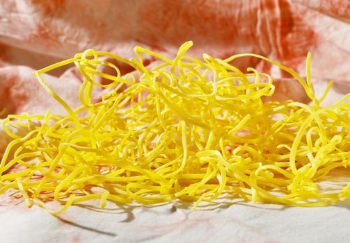 Uncooked pasta fettuccine on colored background , yellow flat thick pasta made with egg and flour