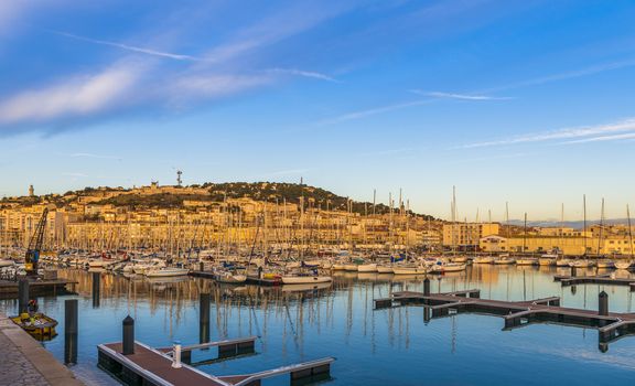 Sunrise over the Sète marina, which lights up the buildings on the slopes of Mont Saint-Clair.