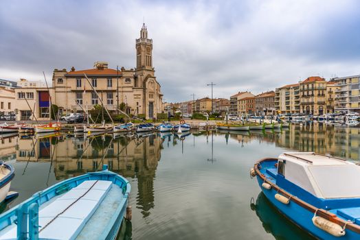 Boats on the Royal Canal in Sète, and the old chamber of commerce in the background in Occitanie in Hérault in the south of France
