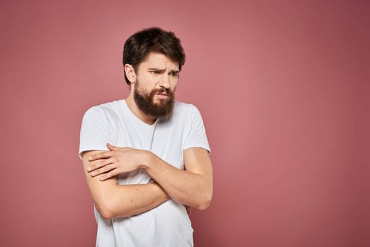 Man in white t-shirt emotions lifestyle facial expression cropped view pink background. High quality photo