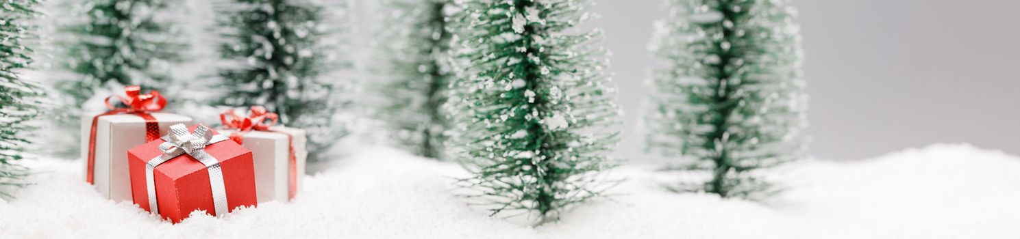 Christmas gifts in fir tree forest under snow