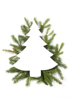 Christmas white fir tree shaped blank card with copy space and decor of fir tree branch isolated on white background