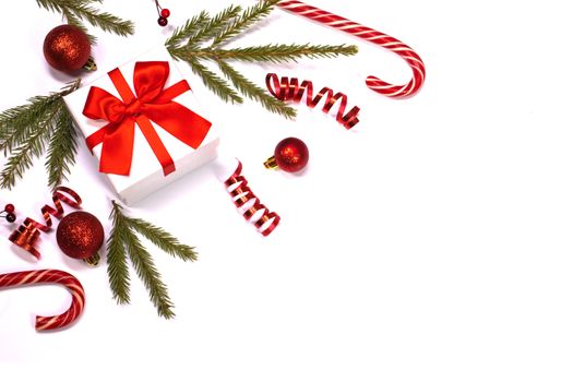 Christmas composition of green fir tree branch, Xmas gift and candy canes isolated on white background. Top view, flat lay. Copy space for text