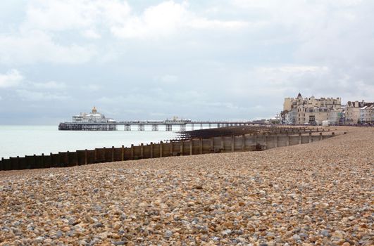 Eastbourne pebble beach in East Sussex with the famous Eastbourne pleasure pier above the sea in the distance