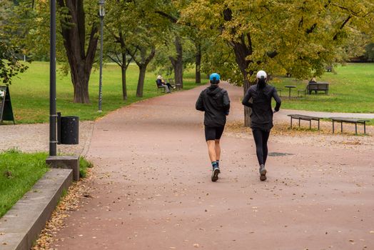 Man and woman are running and talking on Letna Park in Autumn 2020 on Prague 6, during quarantine period due to outbreak of COVID-19 as winter is starting, Czech Republic
