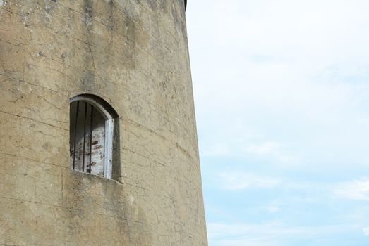 Window with metal bars set into the thick wall of the Martello tower known as Wish Tower in the coastal town of Eastbourne, East Sussex