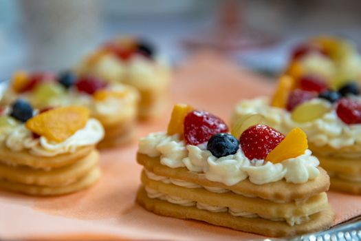 dessert of cream cookies and fruits on a festive table.