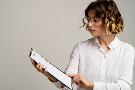 Business woman with folder of documents in hands on gray background cropped view of work. High quality photo