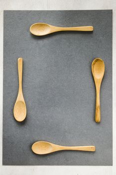Empty wooden spoon on the gray background, wooden dishware and tableware