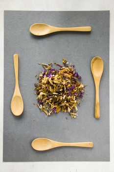 Herbal and natural dry tea set, variation and collection of tea and wooden spoons on the gray background