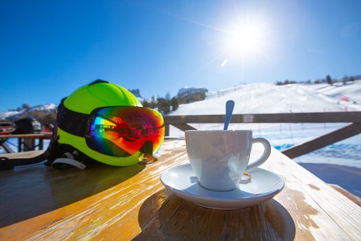 Cup of Cappuccino coffee on table in cafe at ski resort in Italy Dolomites alps