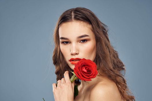 woman with a rose in her hands naked shoulders evening makeup red lips. High quality photo