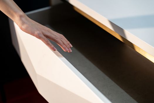 Woman open shelf, pull open drawer wooden in cabinet.