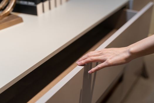 Woman open shelf, pull open drawer wooden in cabinet.