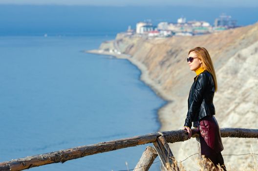 The girl examines the seascape from the mountain, close-up on the girl