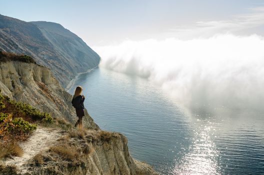 Girl from the mountain watching the clouds above the sea