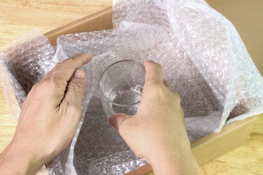 hand of man hold bubble wrap cover glass for protection product cracked or insurance During transit  