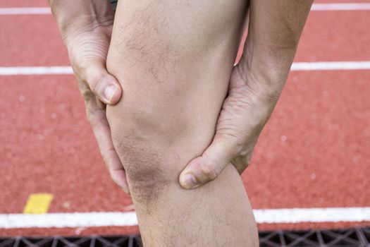 Tendon knee joint problems on Man leg from exercise In the stadium.  
