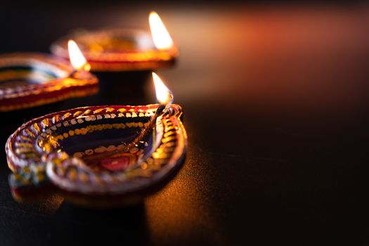 Indian festival Diwali, Diya oil lamps lit on colorful rangoli. Hindu traditional. Happy Deepavali. Copy space for text.