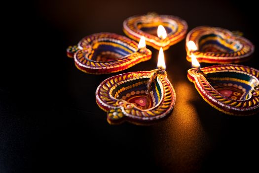 Indian festival Diwali, Diya oil lamps lit on colorful rangoli. Hindu traditional. Happy Deepavali. Copy space for text.