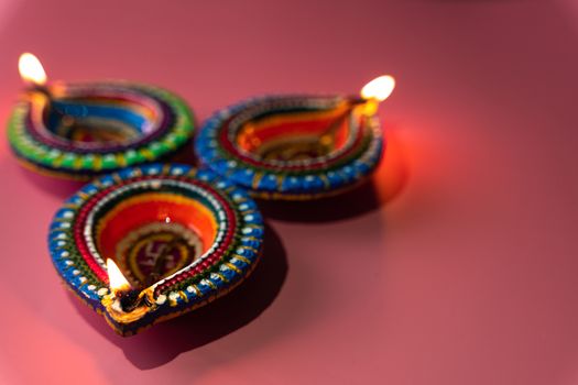 Indian festival Diwali, Diya oil lamps lit on colorful rangoli. Hindu traditional. Happy Deepavali. Copy space for text.