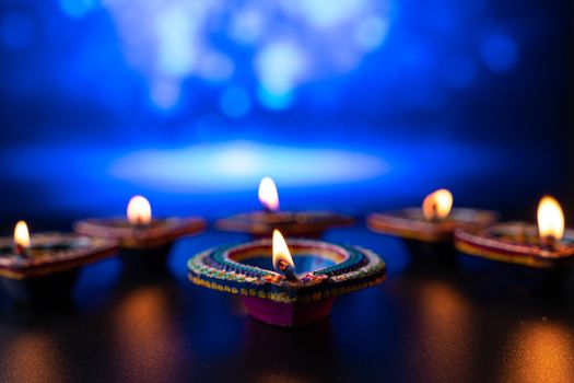 Indian festival Diwali, Diya oil lamps lit on colorful rangoli. Hindu traditional. Happy Deepavali. Copy space for text.