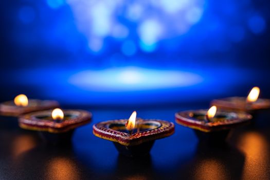 Indian festival Diwali, Diya oil lamps lit on colorful rangoli. Hindu traditional. Happy Deepavali. Copy space for text.