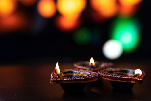 Indian festival Diwali, Diya oil lamps lit on colorful rangoli. Hindu traditional. Happy Deepavali. Copy space for text.