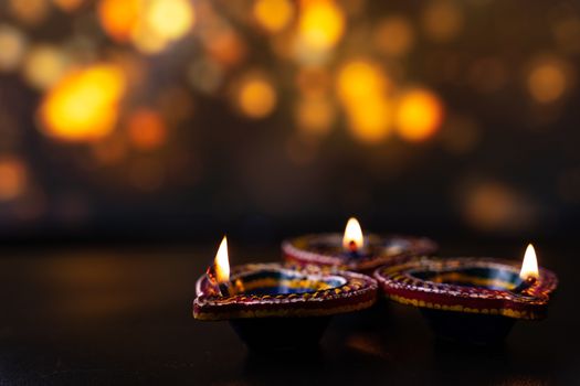 Indian festival Diwali, Diya oil lamps lit on colorful rangoli. Hindu traditional. Happy Deepavali. Copy space for text.