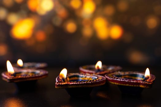 Indian festival Diwali, Diya oil lamps lit on colorful rangoli. Hindu traditional. Happy Deepavali. Copy space for text.