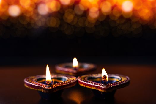 Indian festival Diwali, Diya oil lamps lit on colorful rangoli. Hindu traditional. Happy Deepavali. Copy space for text.