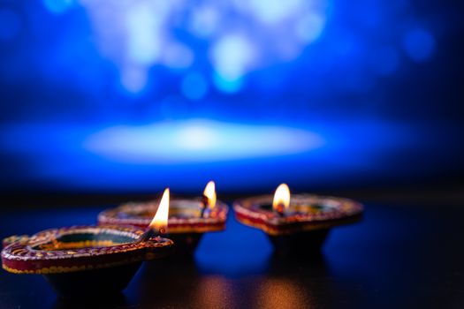 Indian festival Diwali, Diya oil lamps lit on colorful rangoli. Hindu traditional. Happy Deepavali. Copy space for text.