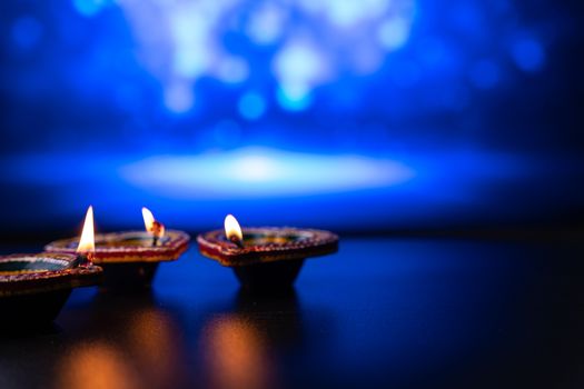 Indian festival Diwali, Diya oil lamps lit on colorful rangoli. Hindu traditional. Happy Deepavali. Copy space for text.
