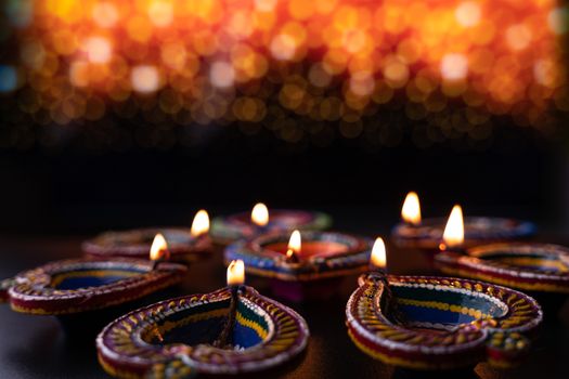 Indian festival Diwali, Diya oil lamps lit on colorful rangoli. Hindu traditional. Happy Deepavali. Copy space for text.