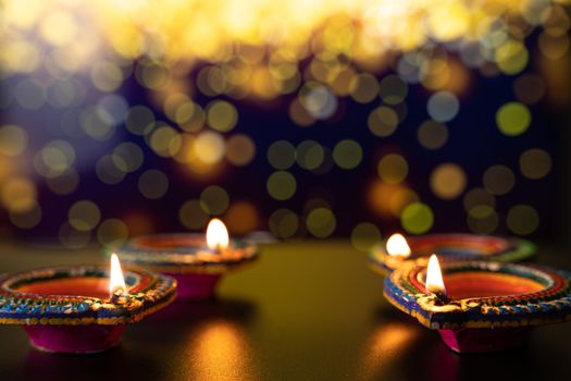 Indian festival Diwali, Diya oil lamps lit on colorful rangoli. Hindu traditional. Happy Deepavali. Copy space for text.