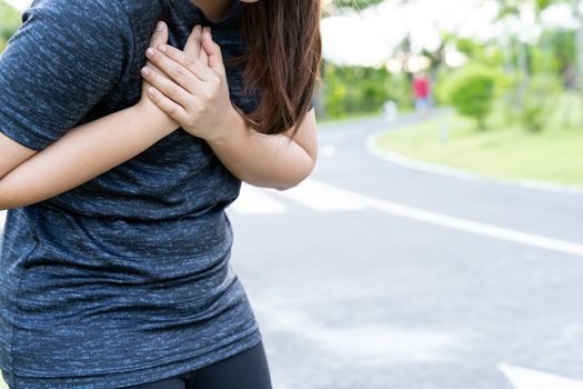 Exhausted female runner suffering painful angina pectoris or asthma breathing problems after training hard on summer. Running over training consequence.