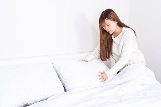 Beautiful Asian women making bed in room early in the morning. daily life concept.