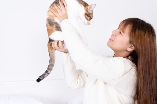 Woman at home holding her lovely fluffy cat. Multicolor tabby cute kitten. Pets and lifestyle concept.