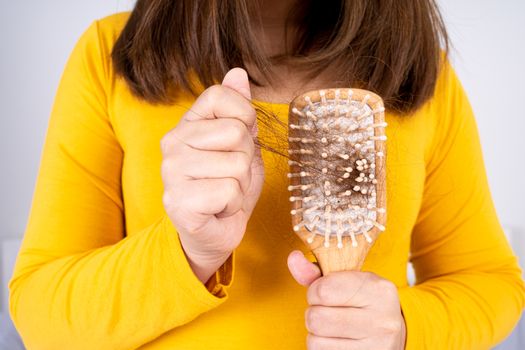 Hair fall problem, closeup hand holding comb and problem hair. Healthcare medical or daily life concept.