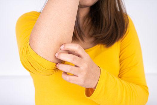 Female scratching her arm on white background with copy space. Medical, healthcare for advertising concept.