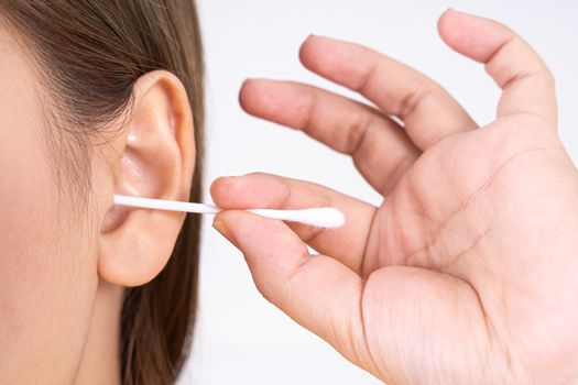 woman cleaning her ear with a cotton swab. A woman suffered an infection after using the sticks incorrectly.