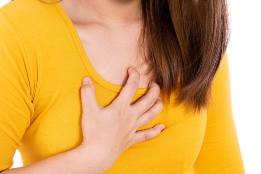 Woman touching her heart or chest isolated white background. Healthcare medical or daily life concept.