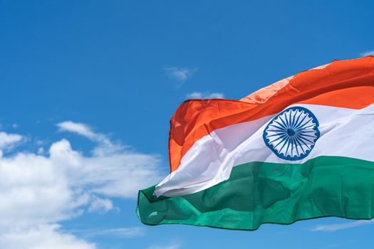 Waving India flag under blue sky background.