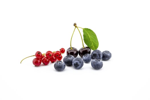 Fresh assorted berries including blueberries, cherries and red currants isolated on white background