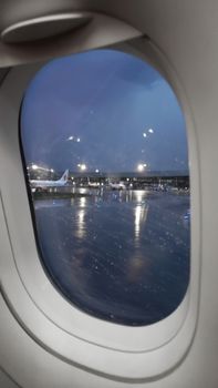 view from the plane to the airport territory in the evening, rainy weather.