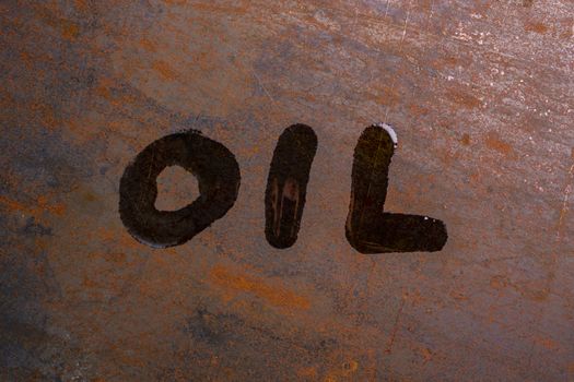 handwritten word oil on rusted sheet metal surface - close-up with selective focus conceptual photography