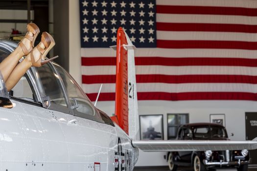 A beautiful blonde model poses with a vintage WWII aircraft