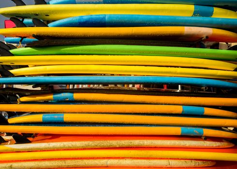 Colorful surfboards in a horizontal stack