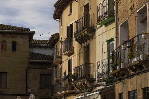 Ayerbe, Spain - October 15, 2020: Picturesque balconies, facades and houses in Plaza of Ramon y Cajal, Ayerbe, Huesca.